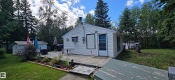 White siding exterior with a spacious wooden deck - 