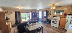 Open-concept living area featuring wood-finish flooring and paneled walls - 