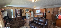 Open-concept living space with wood-finish flooring, paneled walls, and a dropped ceiling - 