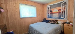 Room featuring vertical wood-paneled walls and a wood-finish ceiling - 