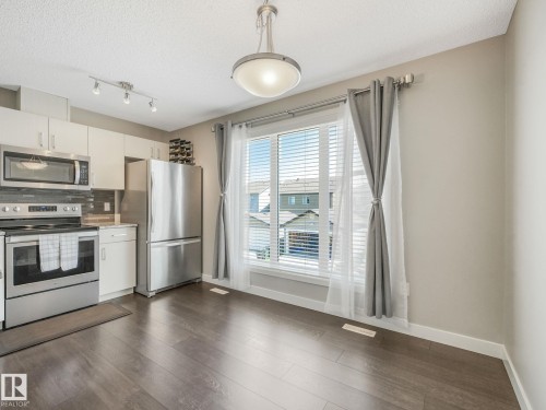 Kitchen dining area featuring dark wood-finish flooring - 55 4470 Prowse Road, Edmonton, AB 