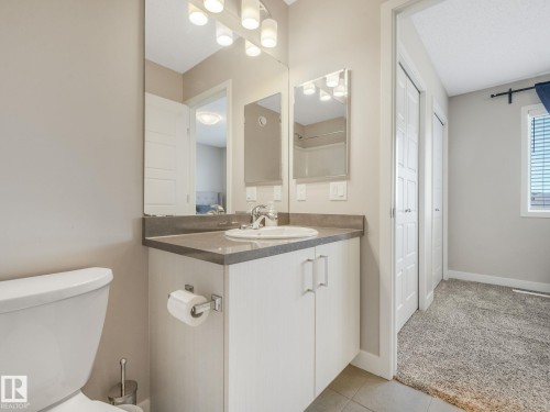 Vanity with a single basin sink, wall-mounted mirror, and vanity lighting - 55 4470 Prowse Road, Edmonton, AB 