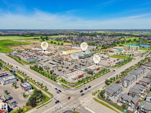 Aerial perspective showcasing a commercial development with multiple retail buildings, expansive parking areas, and mature landscaping - 55 4470 Prowse Road, Edmonton, AB 