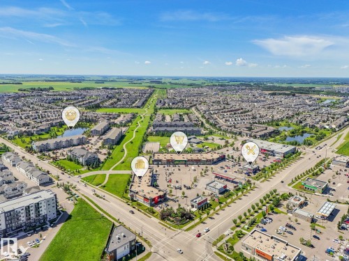 Aerial perspective showcasing a developed community with residential areas, commercial establishments, and green spaces - 55 4470 Prowse Road, Edmonton, AB 