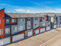 Modern multi-story townhome featuring a neutral color palette with vibrant orange accents - 55 4470 Prowse Road, Edmonton, AB 