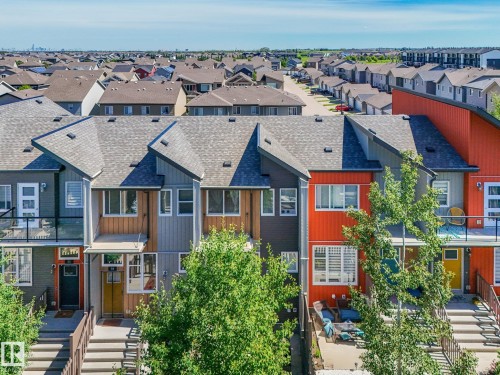 Contemporary townhome exterior featuring multi-toned siding, gabled roofs, and an upper-level balcony with glass railing - 55 4470 Prowse Road, Edmonton, AB 