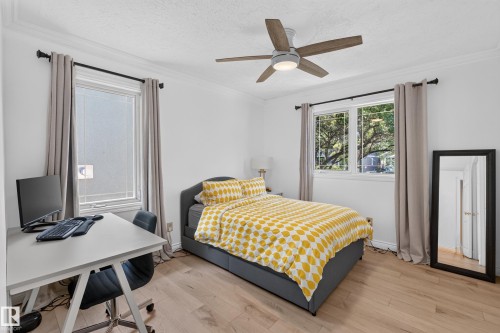 Light wood-finish flooring complements crisp white walls - 11015 122 Street, Edmonton, AB 
