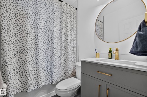 Bathroom vanity with an integrated sink, white countertop, and gold-finish faucet - 11015 122 Street, Edmonton, AB 