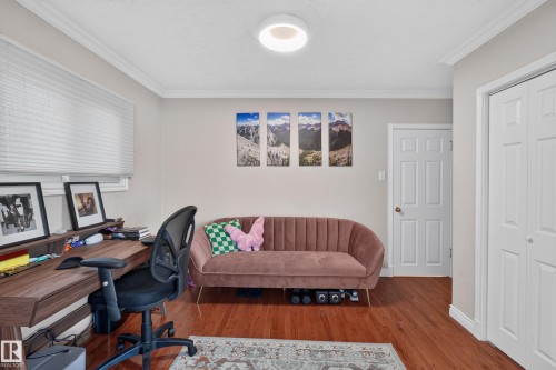 Hardwood-finish flooring featuring a built-in desk with shelving, crown molding, and white trim - 11015 122 Street, Edmonton, AB 