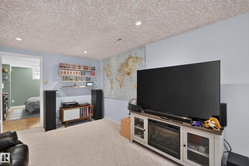 Recessed lighting illuminates this carpeted room featuring a ceiling with acoustic texture - 11015 122 Street, Edmonton, AB 