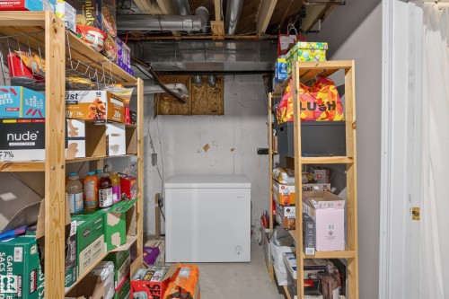 Unfinished basement area featuring exposed ceiling joists and ductwork, a concrete floor, and painted concrete walls - 11015 122 Street, Edmonton, AB 