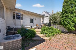Brick paver patio with tiered stone steps leading to a secondary patio area - 