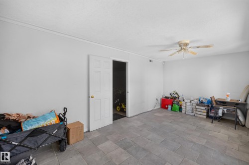 Spacious room featuring light gray tile flooring and white painted walls - 11015 122 Street, Edmonton, AB 