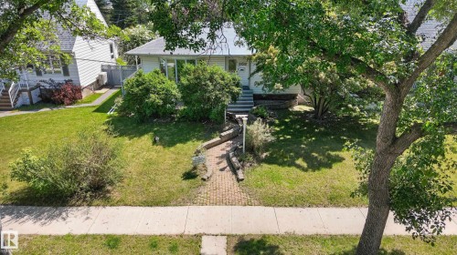 Residential property with a light-colored exterior and a dark-shingled roof - 11015 122 Street, Edmonton, AB 