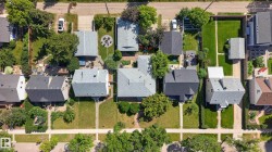 Aerial perspective showcasing multiple properties, each featuring a pitched roof - 