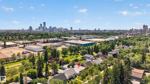 Aerial perspective showcasing the residential area with a prominent city skyline backdrop - 11015 122 Street, Edmonton, AB 