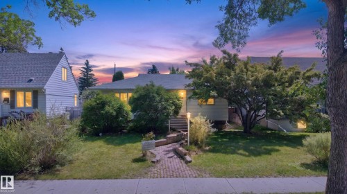 Ranch-style exterior with a gabled roof, featuring a brick paver pathway leading to the front entry - 11015 122 Street Nw, Edmonton, AB 