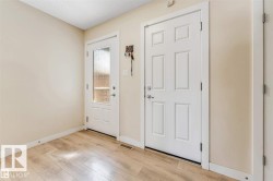 Entryway featuring wood-finish flooring, light neutral wall paint, and white trim - 