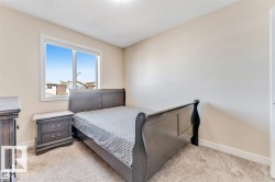 Carpeted bedroom featuring neutral-toned walls, a white trim window, and white baseboards - 