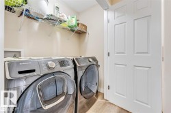 Dedicated laundry area featuring wire shelving, light-toned walls, and wood-finish flooring - 