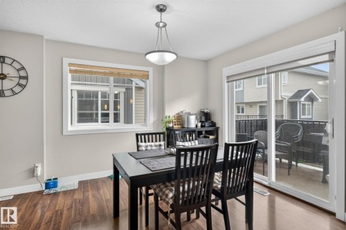 Dining area with wood-finish flooring, a contemporary chandelier, and light-toned wall paint - 89 9535 217 Street, Edmonton, AB 