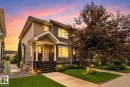 Multi-story residence featuring a covered front porch with stone facade accents and dark-painted stairs with white risers - 89 9535 217 Street, Edmonton, AB 