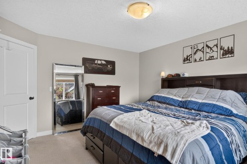 Bedroom featuring neutral wall paint, carpet flooring, a white paneled door, and a flush mount ceiling light - 89 9535 217 Street, Edmonton, AB 