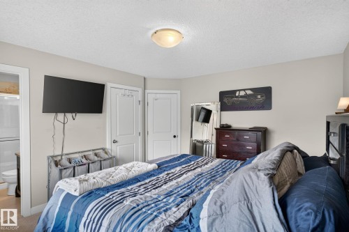 Neutral wall paint with two white interior doors, one leading to a bathroom with a white toilet and vanity - 89 9535 217 Street, Edmonton, AB 