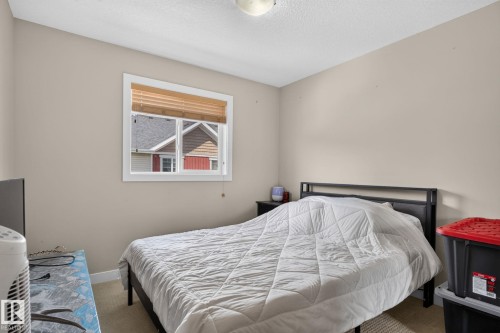 Bedroom featuring neutral wall paint, carpet flooring, a single window with blinds, and an overhead light fixture - 89 9535 217 Street, Edmonton, AB 