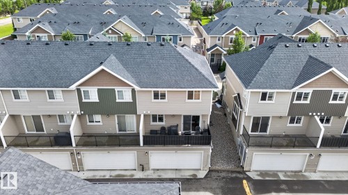 Contemporary townhomes featuring dark gray shingle roofs and light-toned siding - 89 9535 217 Street, Edmonton, AB 