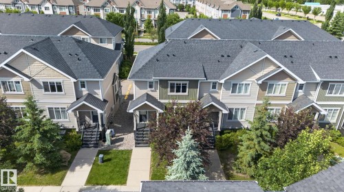 Contemporary townhome exteriors featuring multi-toned siding, dark shingle roofs, covered entryways, and mature landscaping - 89 9535 217 Street, Edmonton, AB 