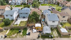 Residential property featuring multiple detached structures, fenced perimeter, and established landscaping - 
