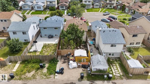 Residential property featuring multiple detached structures, fenced perimeter, and established landscaping - 8316 157 Avenue, Edmonton, AB 