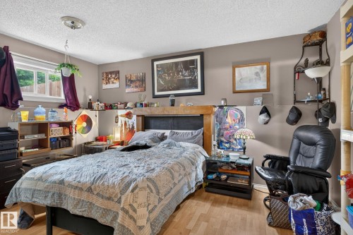 Bedroom featuring wood-finish flooring and a window with natural light - 8316 157 Avenue, Edmonton, AB 