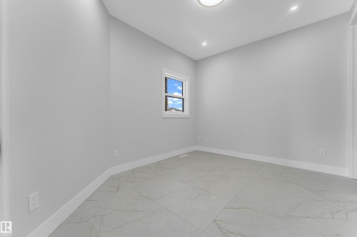 Spacious room featuring light gray walls, large format tile flooring, a window with white trim, a flush mount ceiling light, and recessed lighting - 2611 62 Avenue, Rural Leduc County, AB - Indoor Photo Showing Other Room
