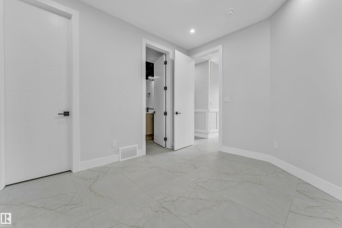 Spacious room featuring large format tile flooring, contemporary baseboards, and bright white walls - 2611 62 Avenue, Rural Leduc County, AB - Indoor Photo Showing Other Room