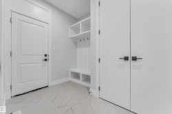 Entryway featuring a built-in bench with storage cubbies and coat hooks - 