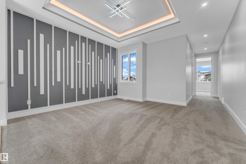 Modern interior featuring a decorative accent wall, recessed lighting, and a tray ceiling with cove lighting - 2611 62 Avenue, Rural Leduc County, AB - Indoor Photo Showing Other Room