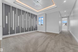 Modern interior featuring a decorative accent wall, recessed lighting, and a tray ceiling with cove lighting - 
