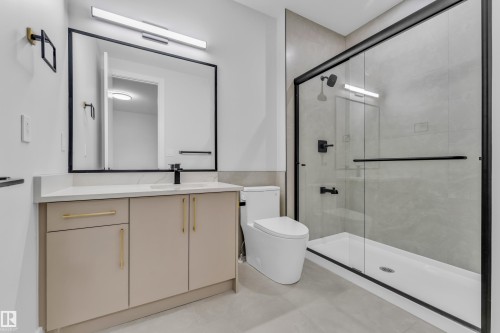Contemporary bathroom featuring a black-framed mirror, sleek linear vanity light, and a modern vanity with a quartz countertop - 2611 62 Avenue, Rural Leduc County, AB - Indoor Photo Showing Bathroom