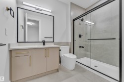 Contemporary bathroom featuring a black-framed mirror, sleek linear vanity light, and a modern vanity with a quartz countertop - 