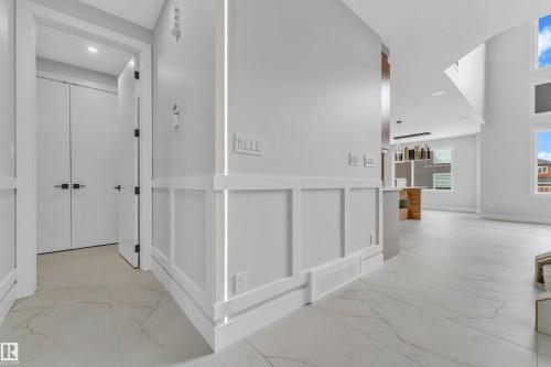Modern entry hall with large format tile flooring and wainscoting detail - 2611 62 Avenue, Rural Leduc County, AB - Indoor Photo Showing Other Room