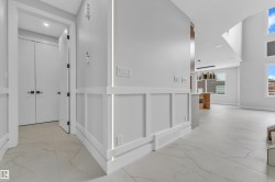 Modern entry hall with large format tile flooring and wainscoting detail - 
