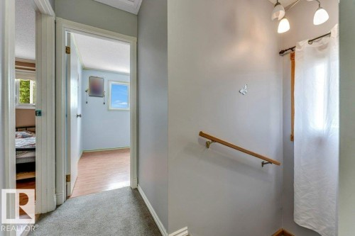Upper-level hallway featuring light gray walls, carpeted flooring, and white trim - 14530 37 Street, Edmonton, AB 