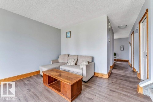 Open-concept living area featuring wood-finish flooring and light gray walls - 14530 37 Street, Edmonton, AB 