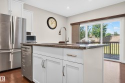 Kitchen island featuring an undermount sink, gooseneck faucet, and stone countertop - 