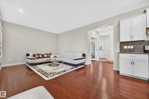 Open-concept living space with dark wood-finish flooring - 1512 Cunningham Cape, Edmonton, AB 