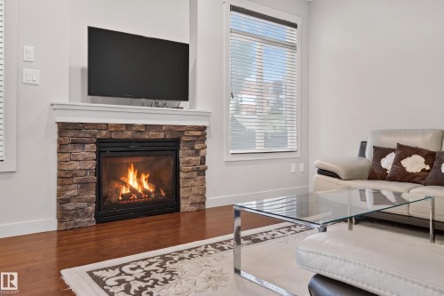Stone-clad fireplace with mantel and hearth - 1512 Cunningham Cape, Edmonton, AB 