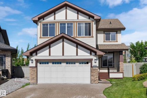 Craftsman-style exterior featuring a prominent two-car garage with paneling and window accents - 1512 Cunningham Cape, Edmonton, AB 