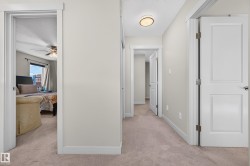 Hallway featuring carpet flooring, white trim, and a flush mount ceiling light fixture - 